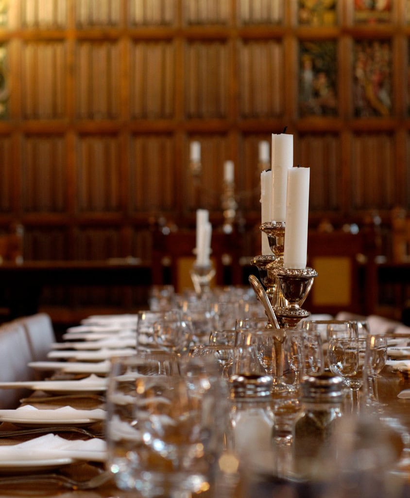 Dining table in hall with candles and silverware