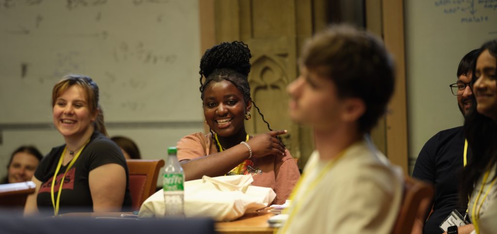 A group of students smiling in a lecture.