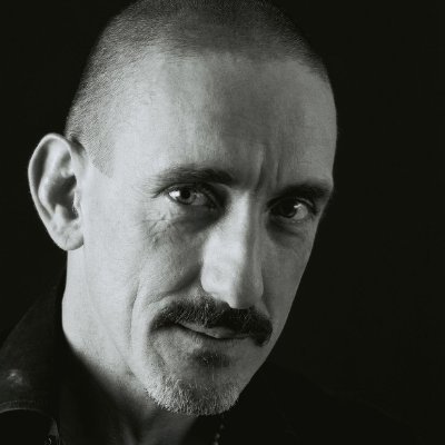 A black and white portrait of Bartlett now. He looks directly into the camera, and is lit very strongly from the left.