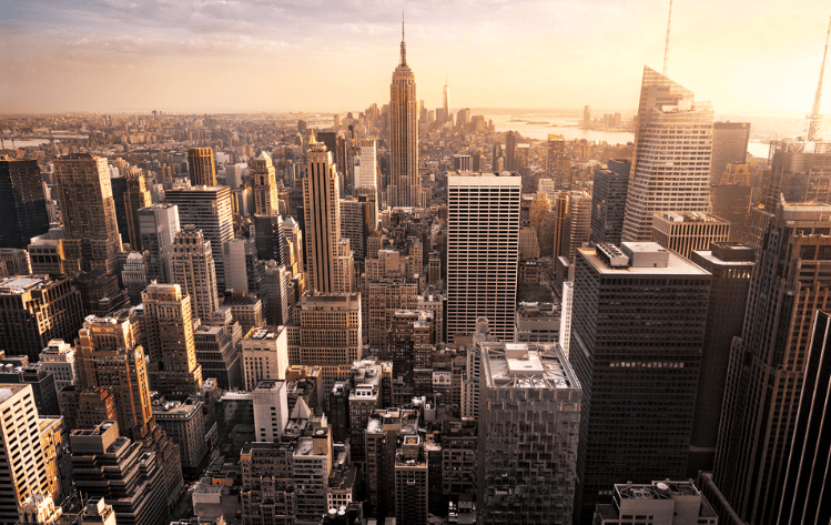 A arial photograph of the New York Skyline from the Chrysler Building at sunset.