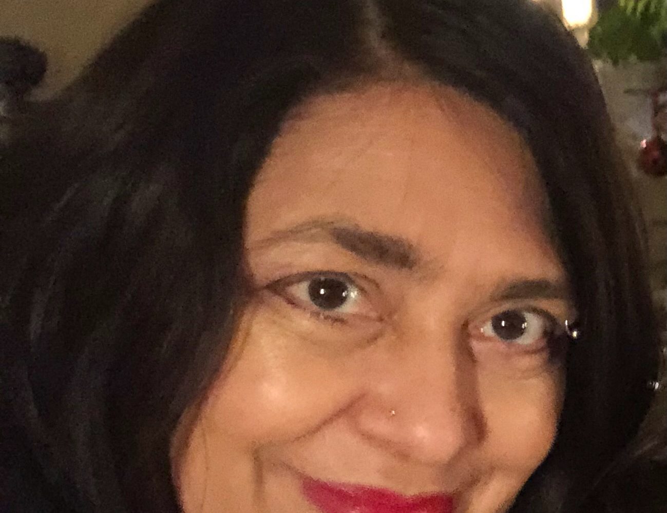 A portrait of Professor Gillian Ramchand. She has dark hair, and is smiling.