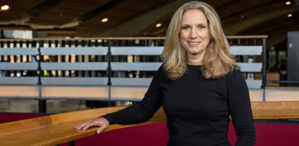 Professor Emily Shuckburgh wears a black shirt sitting at a wooden table