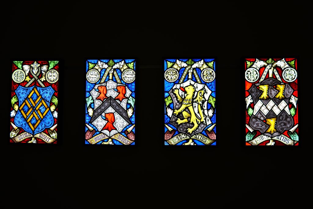 a high res photograph of all hree stained glass panels in reds, blues, greens, and yellows
